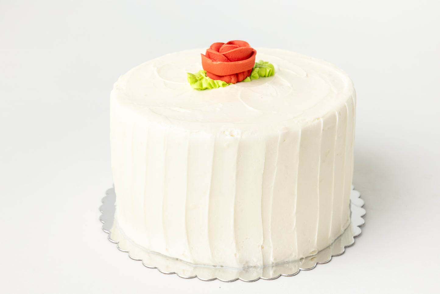 White cake with a red rose decoration on a white background