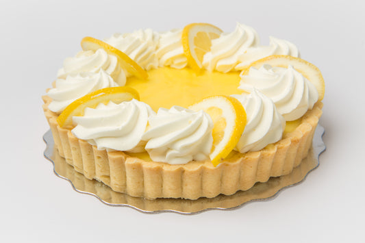 Lemon tart with whipped cream on a white background