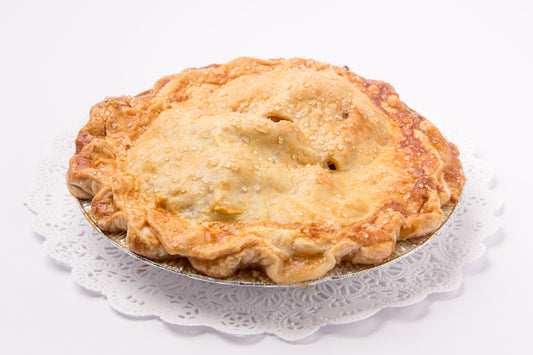 Pastry topped pie on a doily with a white background