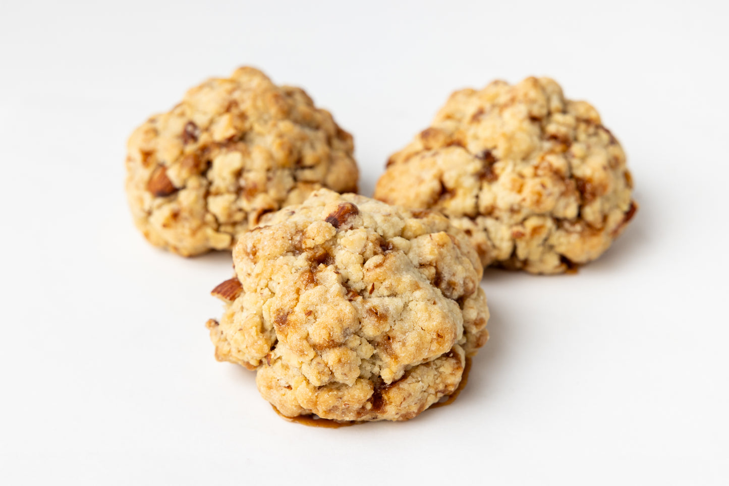 Three almond and skor cookies on a white background