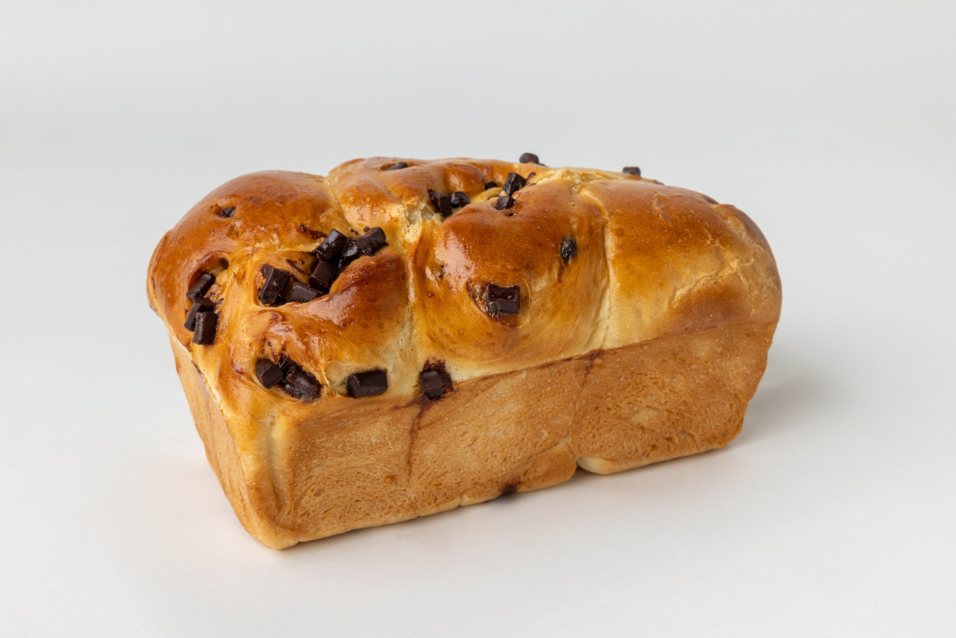 Loaf of chocolate challah bread on a white background