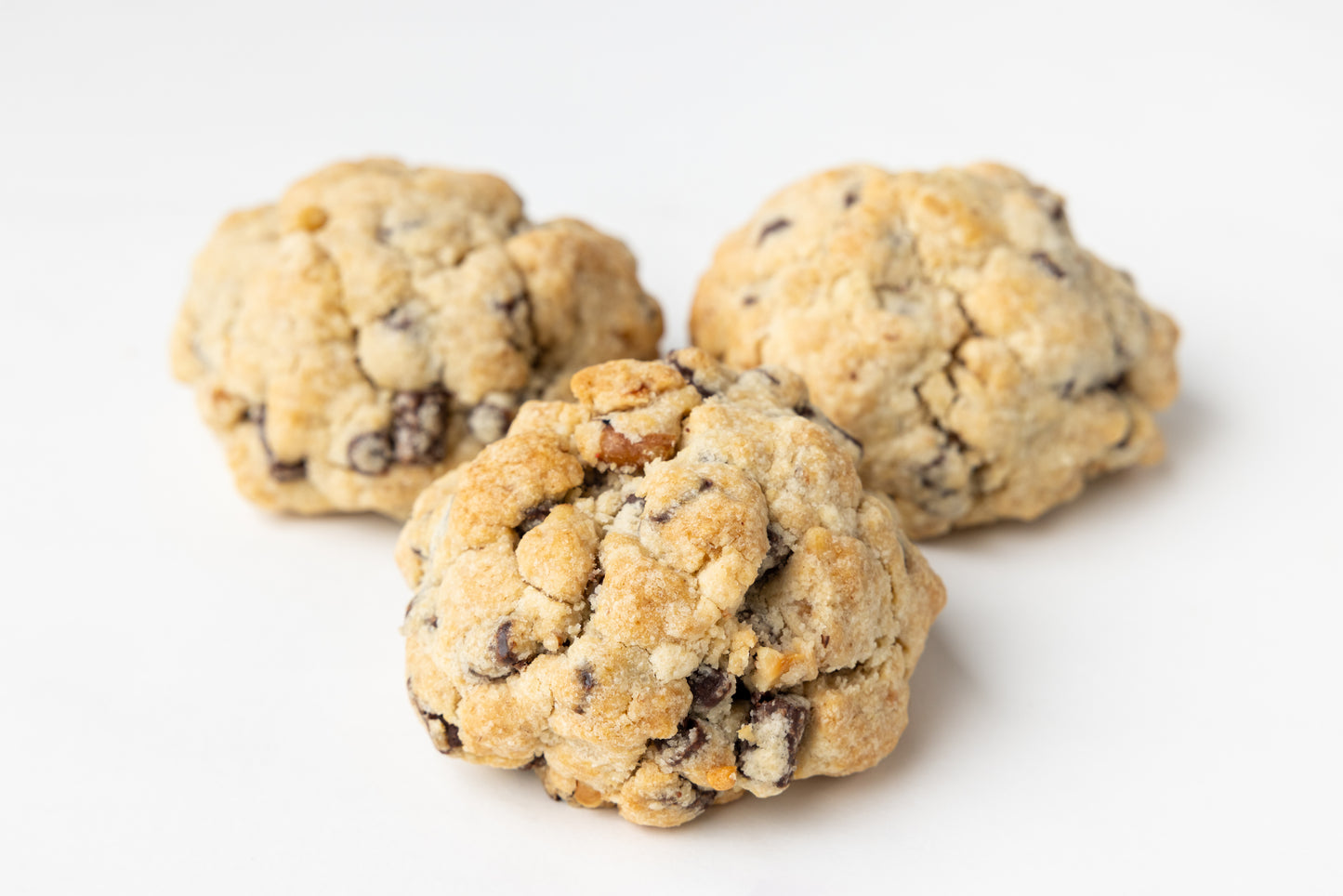 Three chocolate chip cookies on a white background