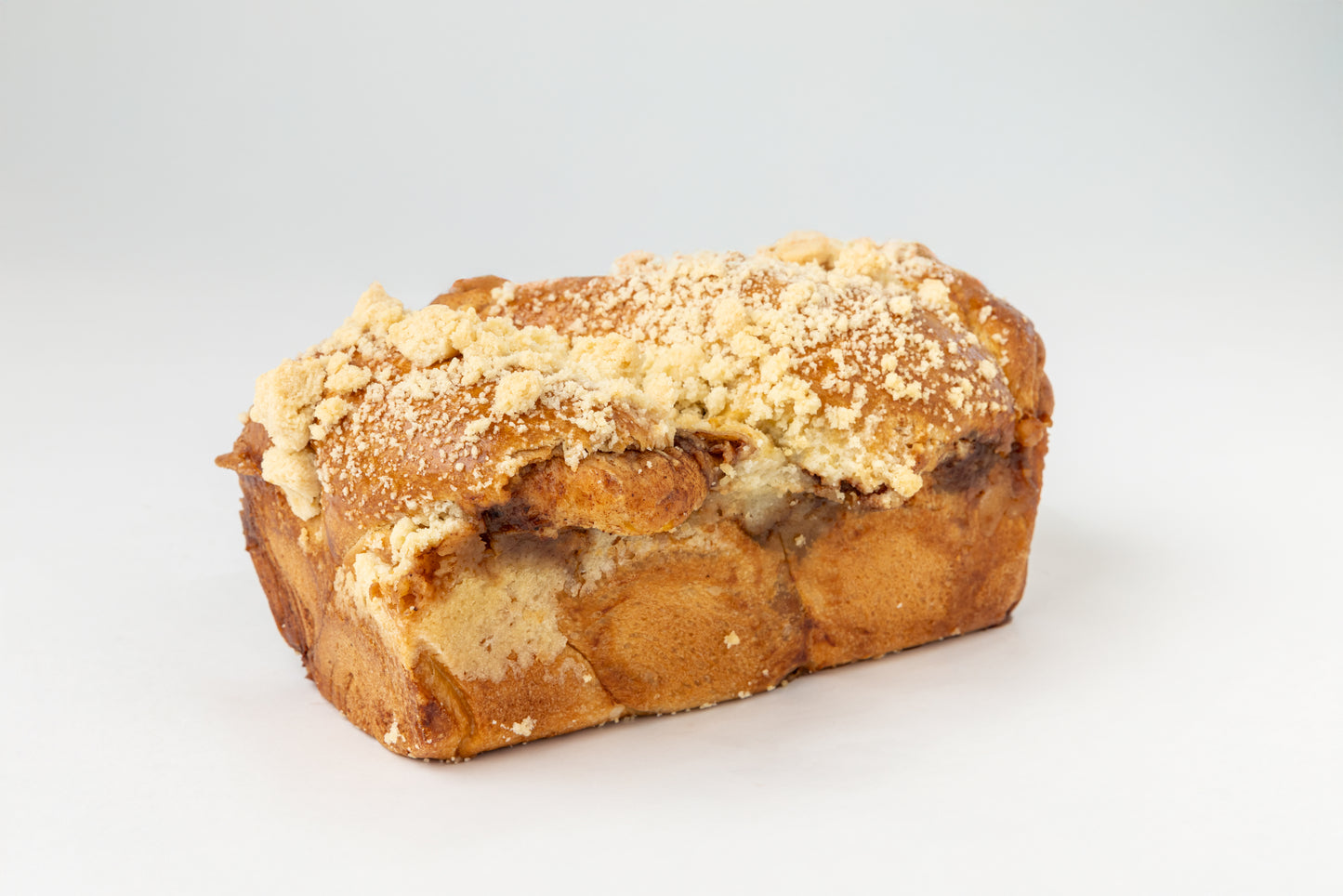 Babka in a loaf shape with crumbly topping on a white background