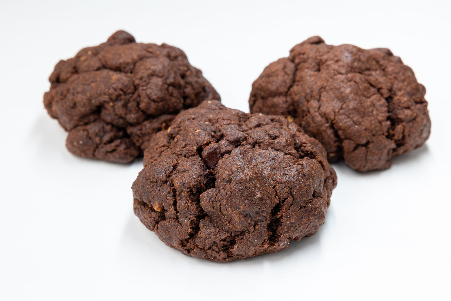 Three double chocolate cookies on a white background