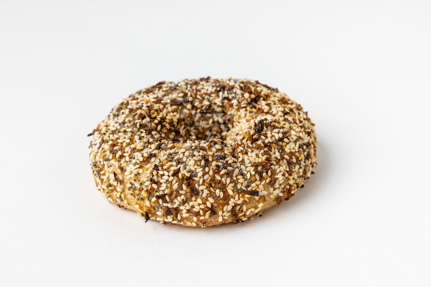 Bagel with everything seasoning on a white background
