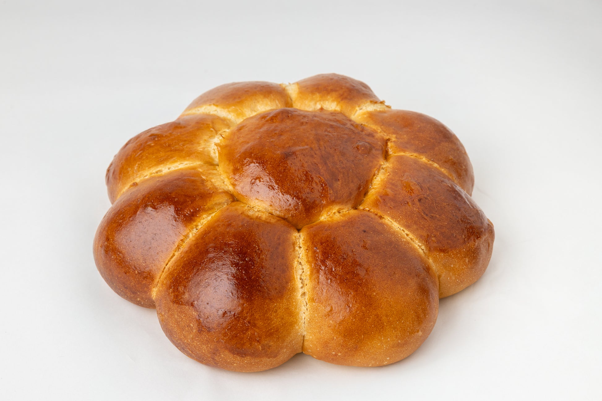 Challah loaf in the shape of  a flower on a white background