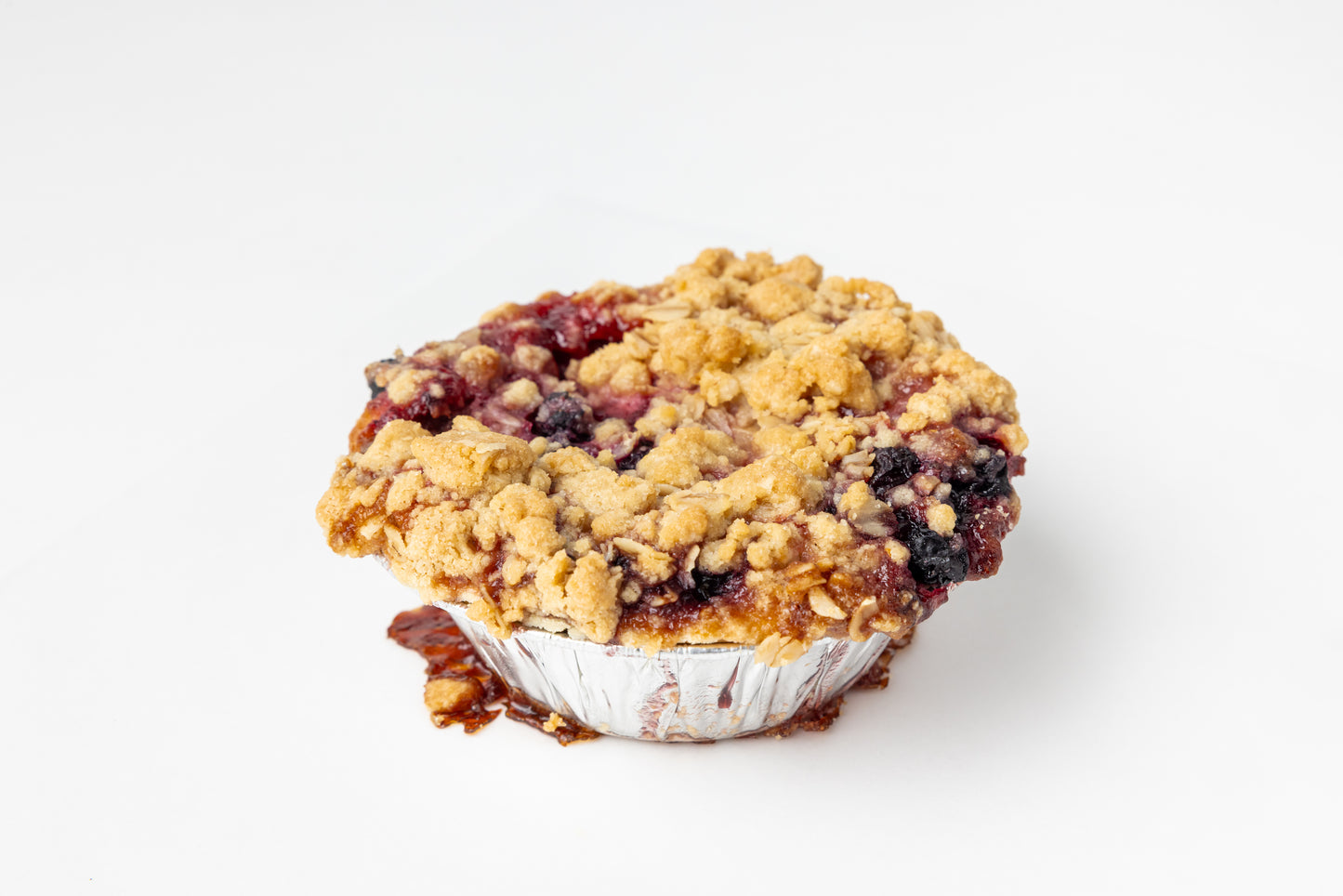 Crumble topped mini pie on a white background