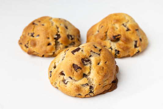 Three chocolate chip cookies on a white background