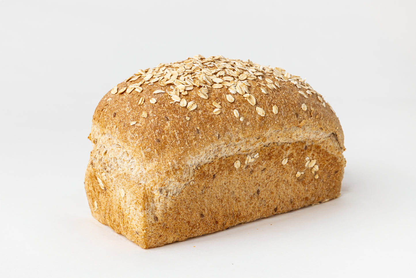 Loaf of bread with oats and seeds on a white background