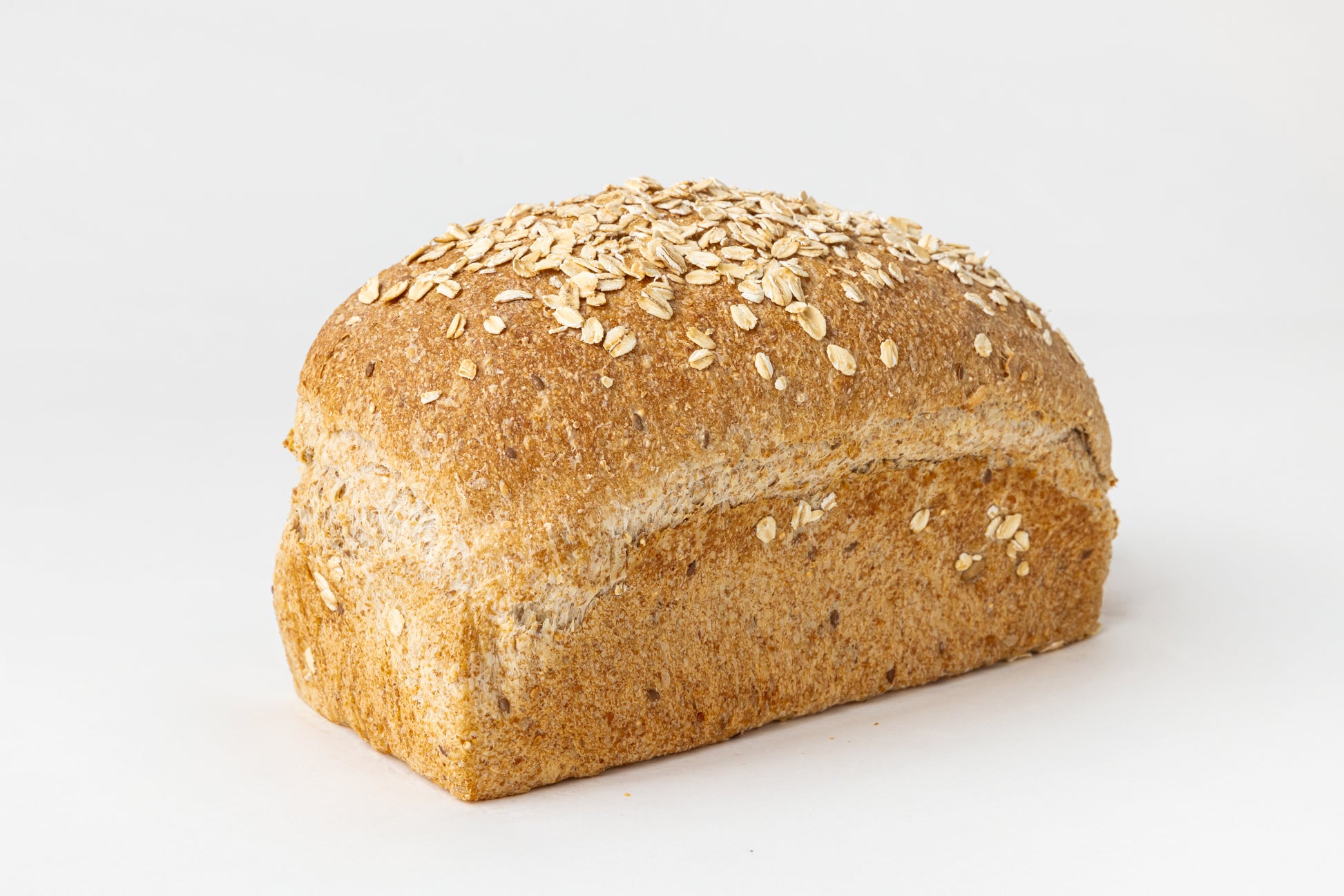 Loaf of bread with oats and seeds on a white background