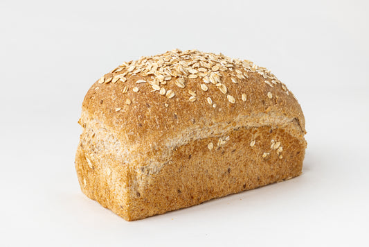 Loaf of bread with oats and seeds on a white background