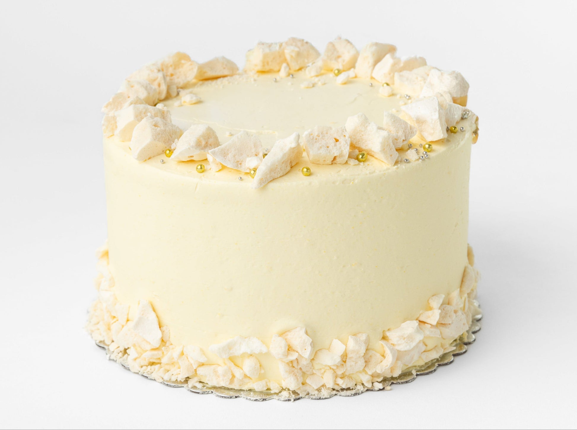 White cake with chunks of meringue around the top and bottom sides on a white background