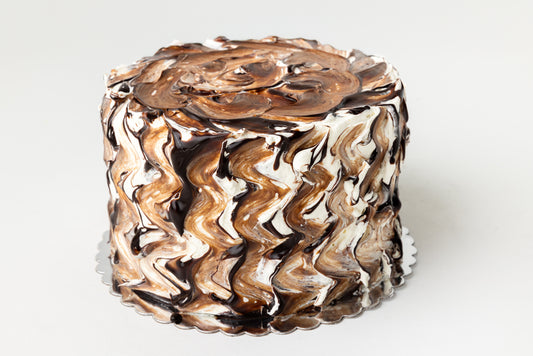 Chocolate and vanilla swirls on a cake with a white background
