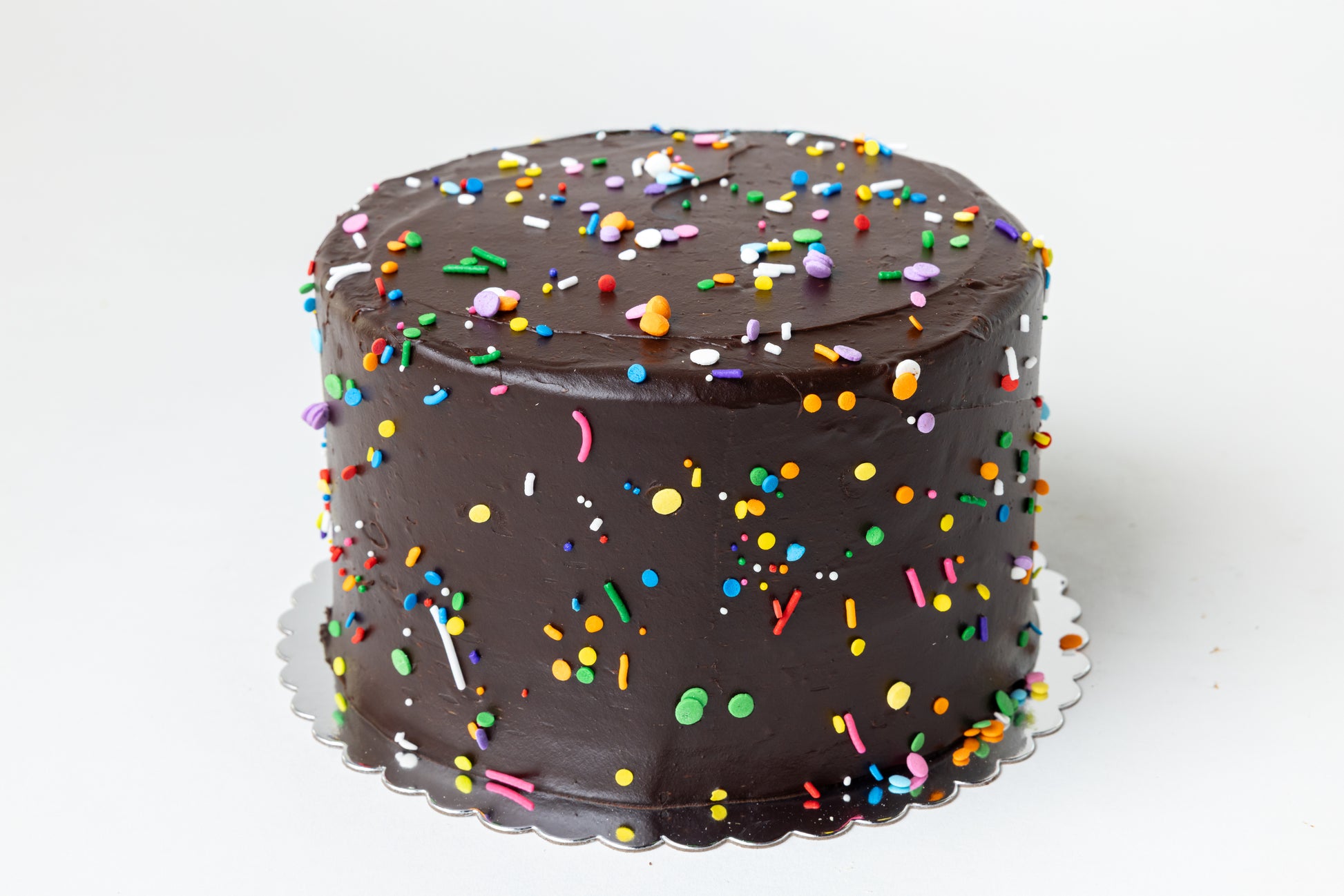 Chocolate cake with colorful sprinkles on a white background