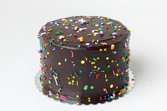 Chocolate cake with colorful sprinkles on a white background