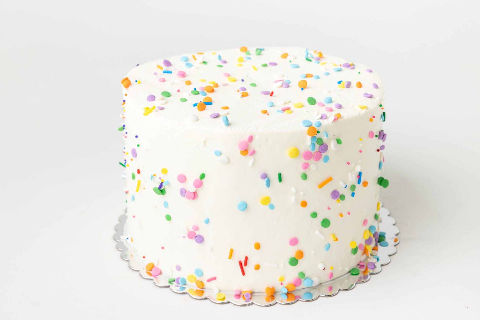 white cake with colorful sprinkles on a white background