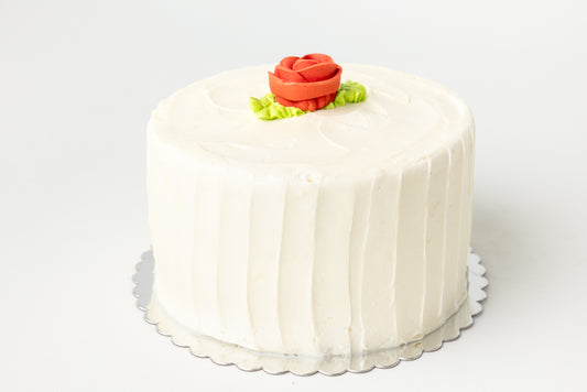 White cake with a red rose decoration on a white background