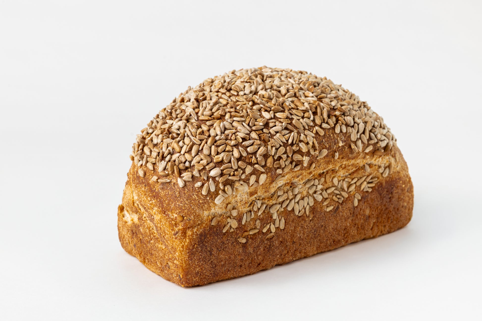 Loaf of bread covered with sunflower seeds on a white background