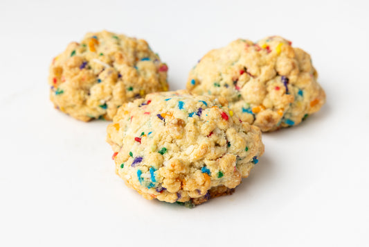 Three cookies with colorful sprinkles on a white background